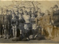 Uczniowie szkoły w Murowańcu, lata pięćdziesiąte XX wieku, zdjęcie grupowe ubrani w mundurki szkolne, w tle drzewo owocowe