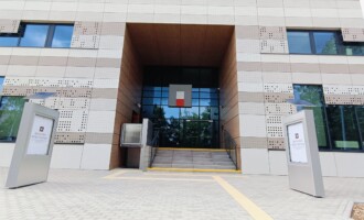 Główne wejście do Archiwum po bokach gabloty wystawowe, logo archiwów państwowych