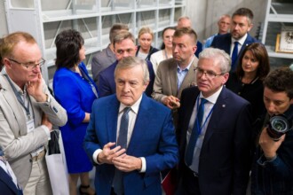 W archiwalnym skarbcu kilkanaście osób, na czele minister w tle półki archiwalne